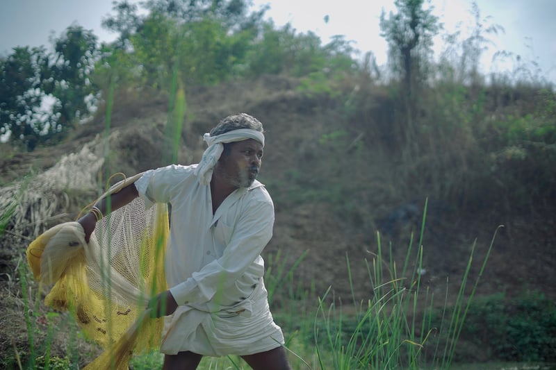 Farmer Bhikaru Bamne prepares to fish from his pond in Asifabad, Telangana.