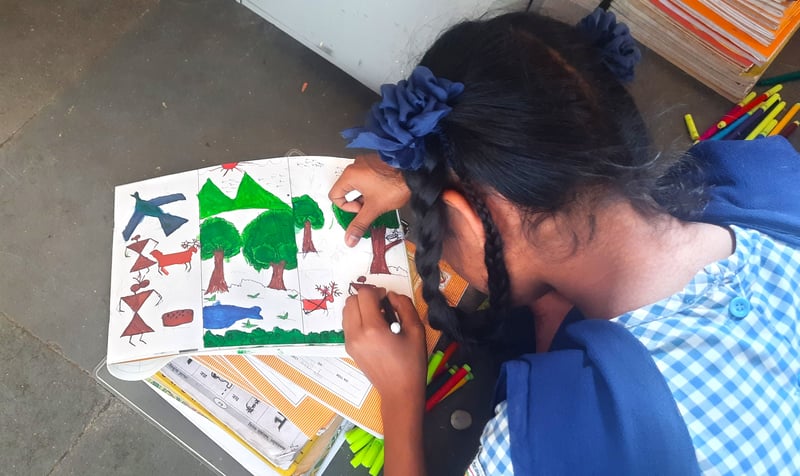 A student from Betegaon Ashram School draws in art class. 